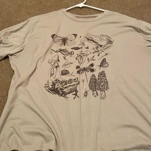 Light brown t-shirt with graphic designs of nature on it size large